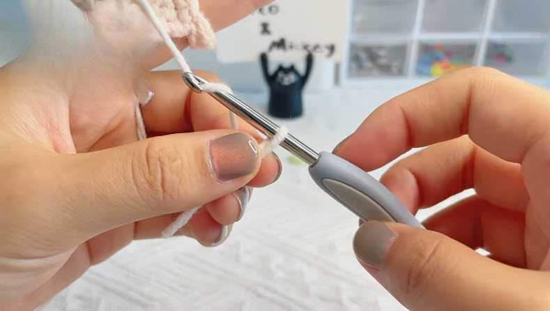 Hand holding a crochet hook with a slip knot loop