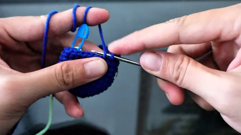 Blue piece worked evenly with green yarn attached.