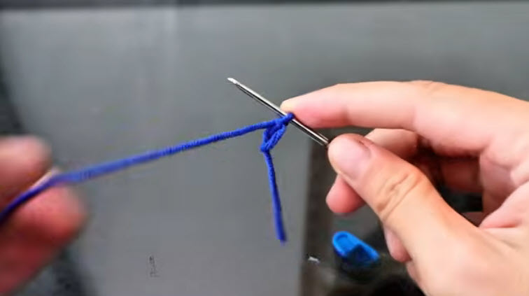 Blue yarn magic ring started on the crochet hook.
