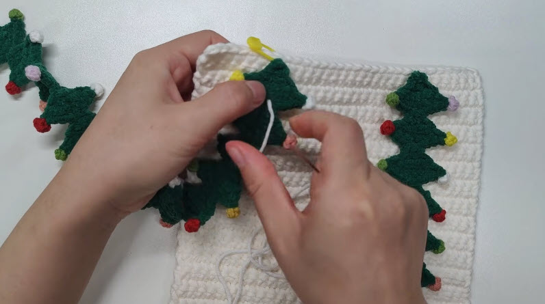 Christmas tree trim attached to white crochet bag panel