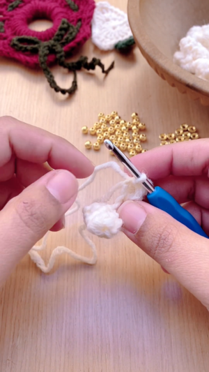 Completed popcorn stitch bead held on the hook.