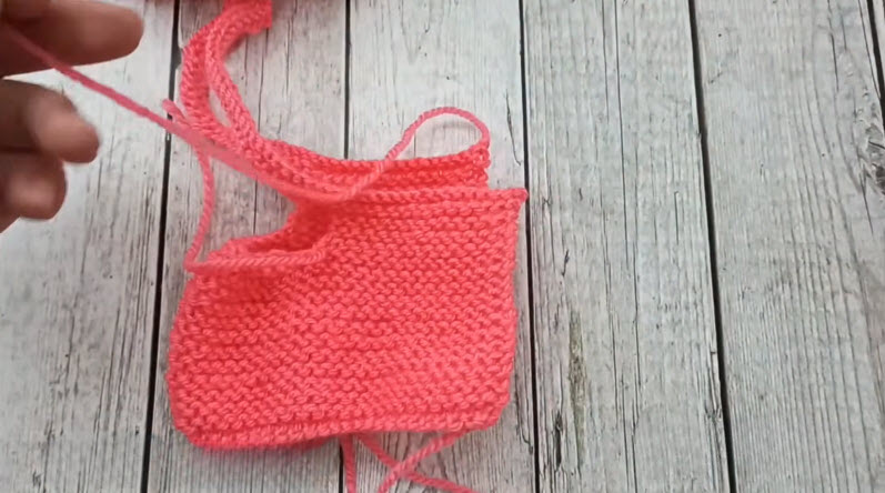 Coral knit baby bootie shape folded and forming