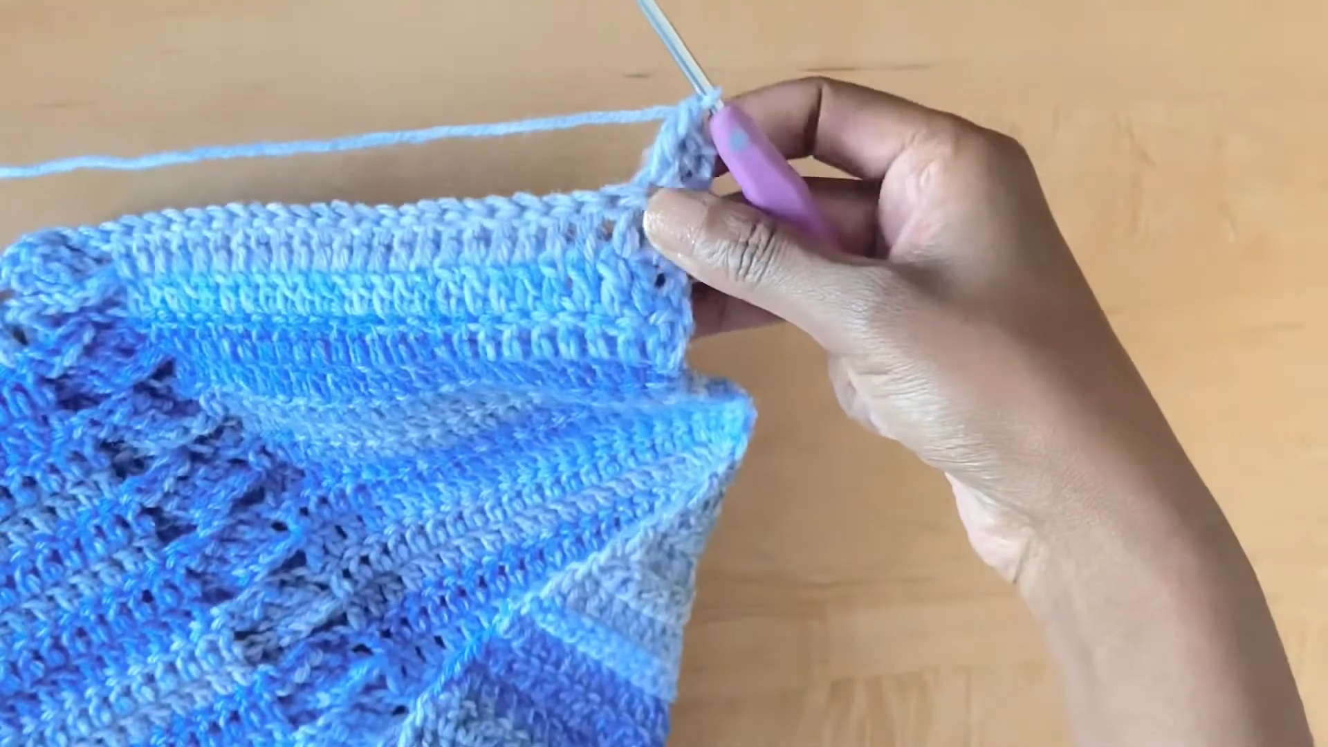 Working edge stitches on blue crochet shrug piece