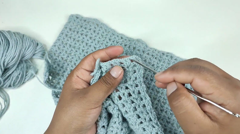 Crocheting blue mesh stitch panel with hook