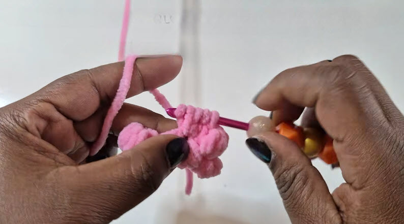 Crocheting bobble stitch row in pink yarn