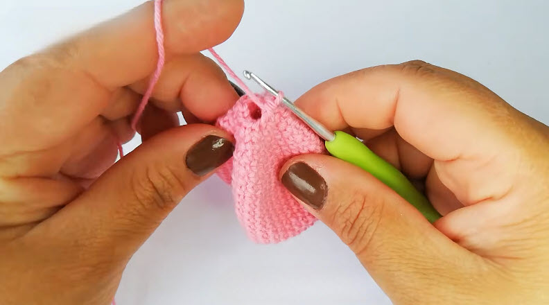 Crocheting pink amigurumi bunny hat piece