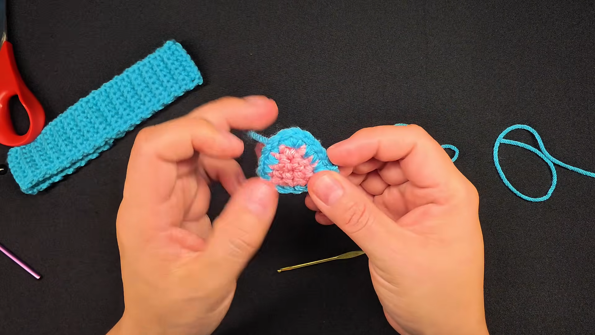 Crocheting pink flower center on turquoise headband