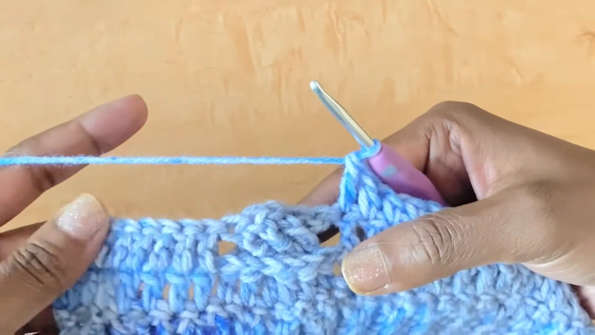 Crocheting stitch pattern on blue cropped shrug