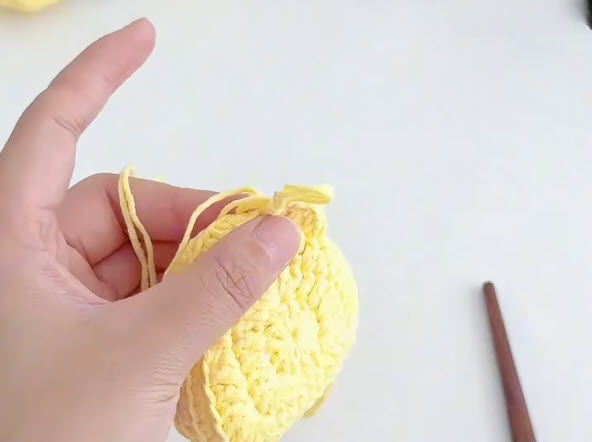 Finished flat yellow crochet disc for the earphone holder.