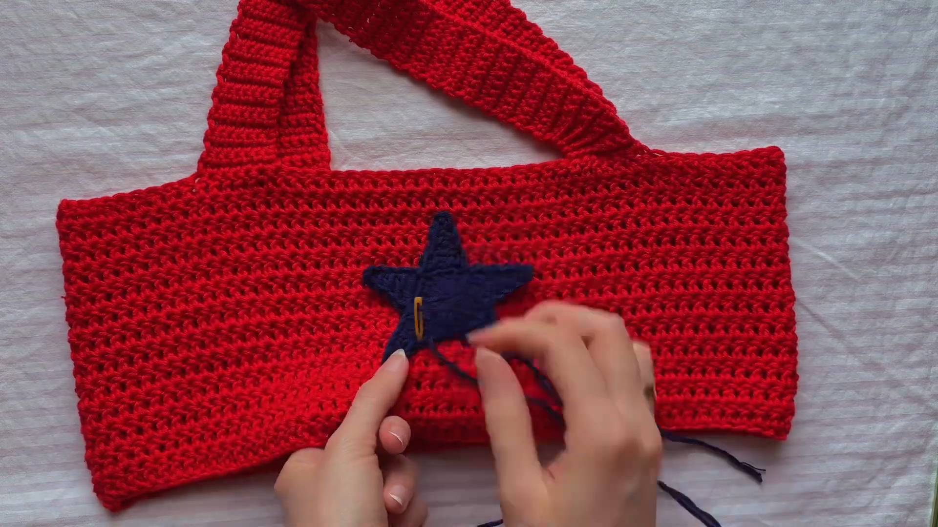 Finished red crochet top with navy star patch on front