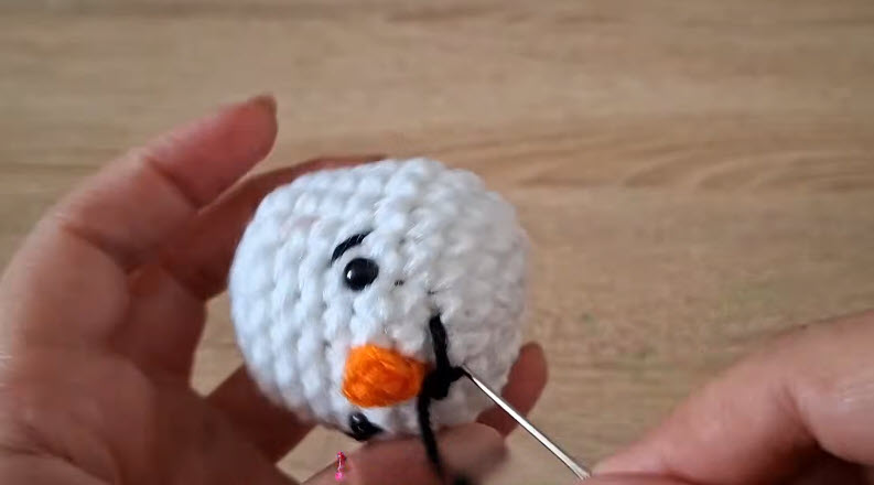 Finished snowman head with bead eyes and orange nose.