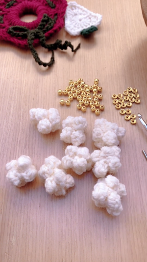 Finished white crochet popcorn beads laid out with gold beads for the