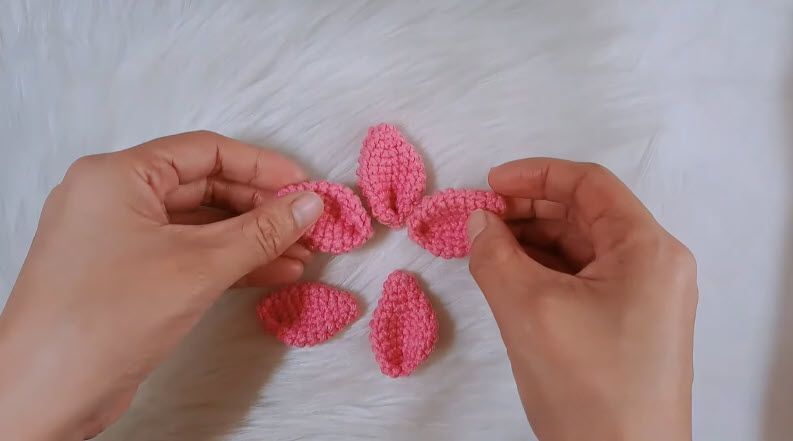 Five pink crochet petals arranged before gluing
