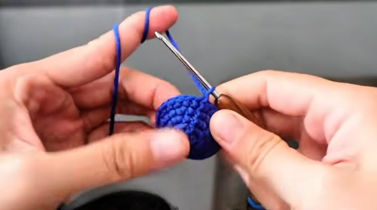 Flat blue crochet disc expanded to 30 stitches.