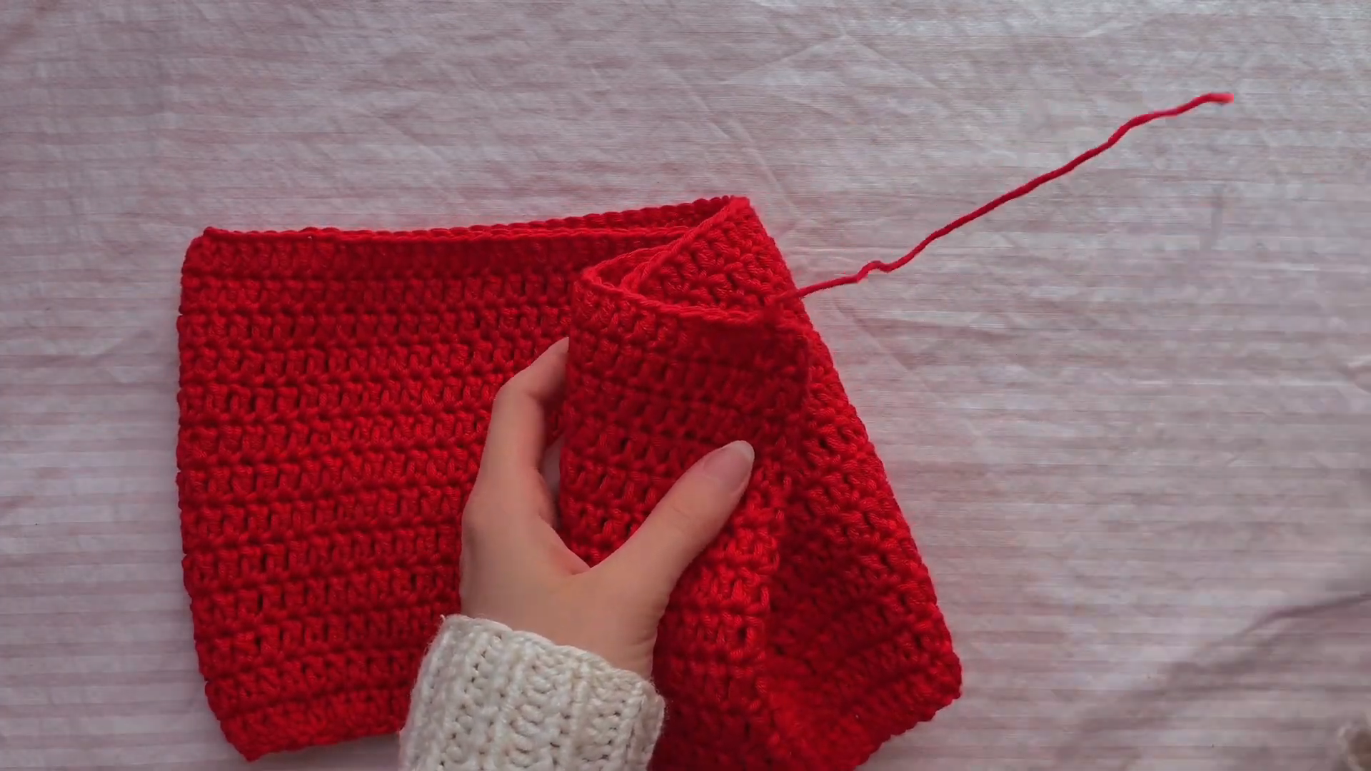 Folded red crochet fabric shaping the one shoulder top