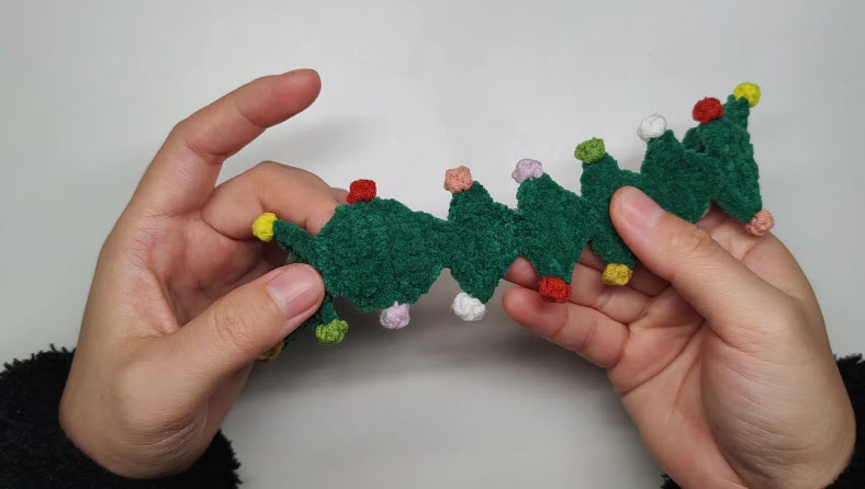 Green crochet Christmas tree trim with colorful ornaments