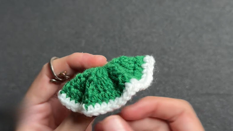 Green crochet piece folded showing textured stitch pattern.
