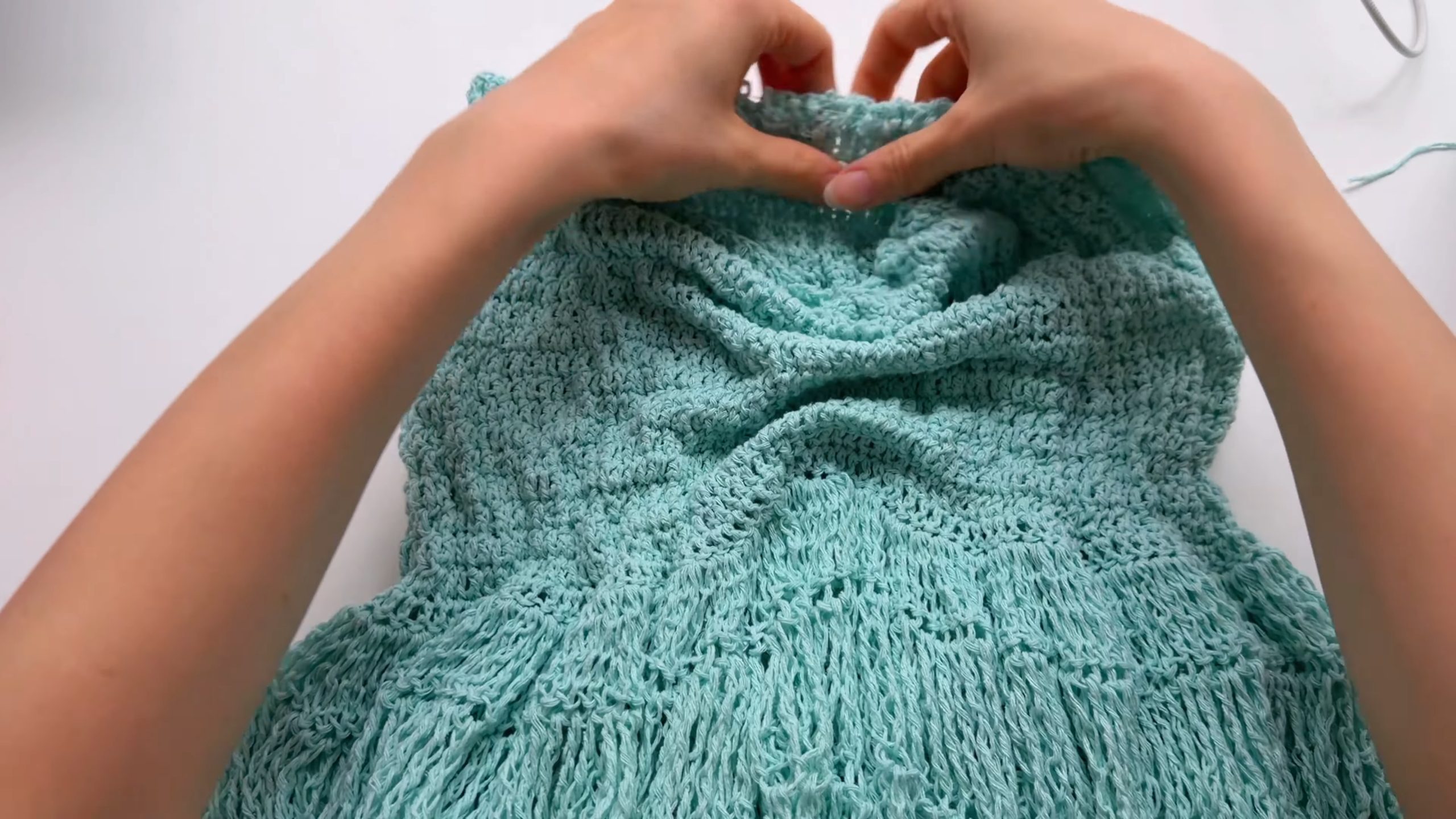Hands shaping mint crochet doll top