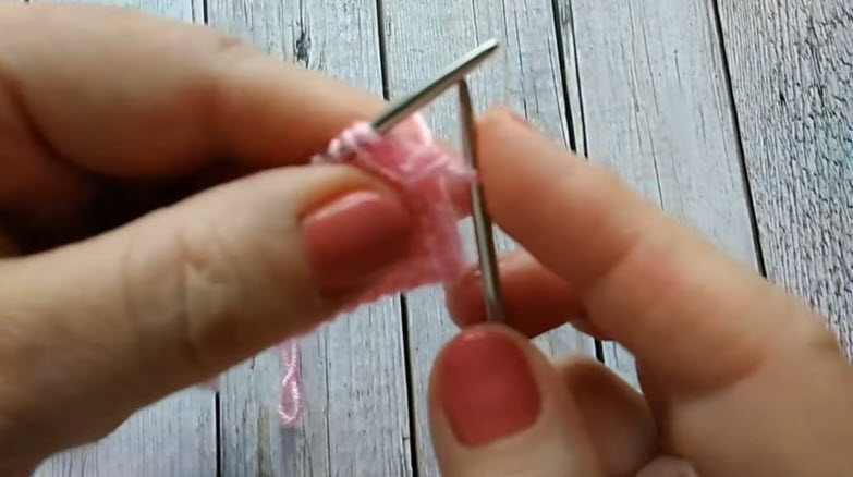 Pink yarn wrapped around double pointed needles