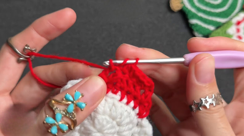Red half double crochet stitches forming a pointed hat edge.