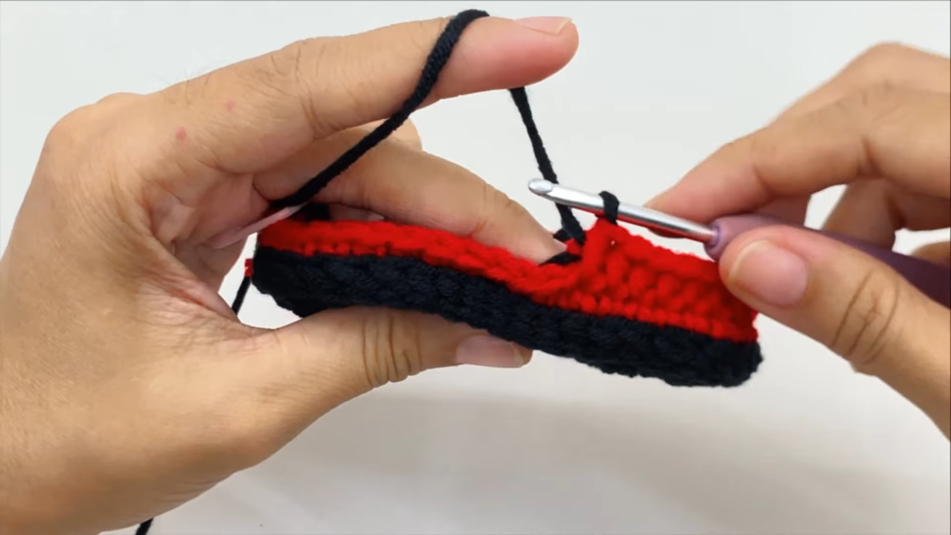 Red yarn sewn on black bootie edge