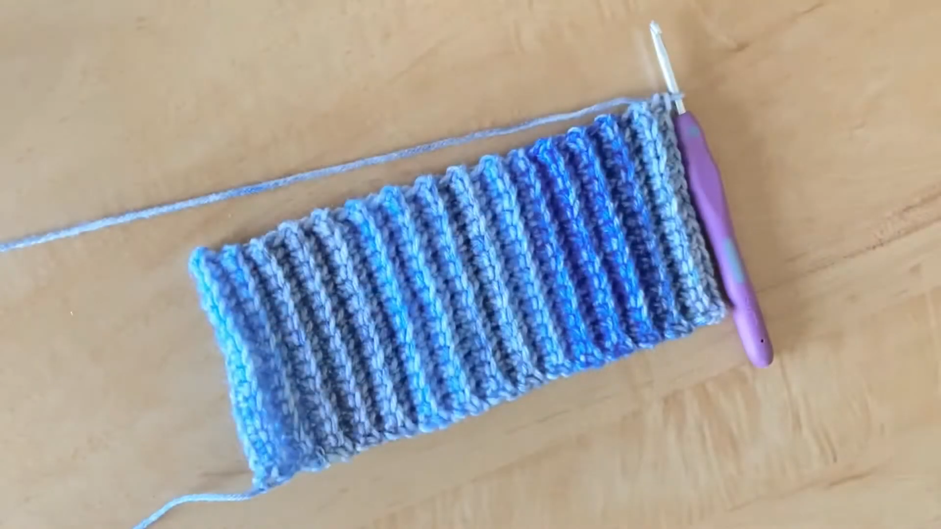 Ribbed blue crochet swatch on wooden table
