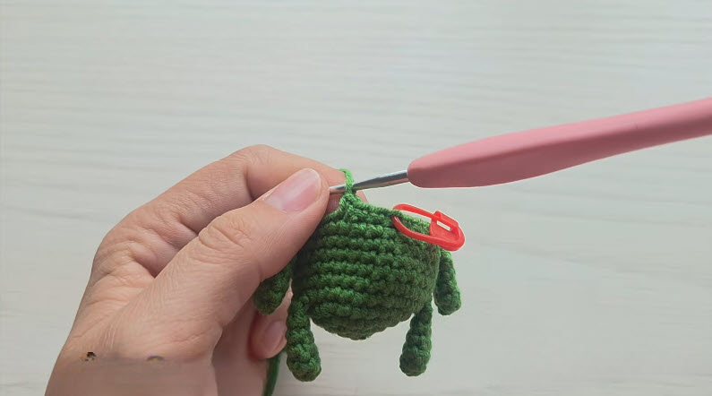 Round twelve decrease stitches shaping green toad body