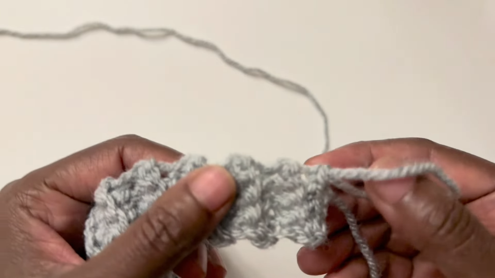 Row of gray crochet stitches on hook