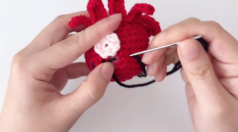 Sewing eye details with needle thread