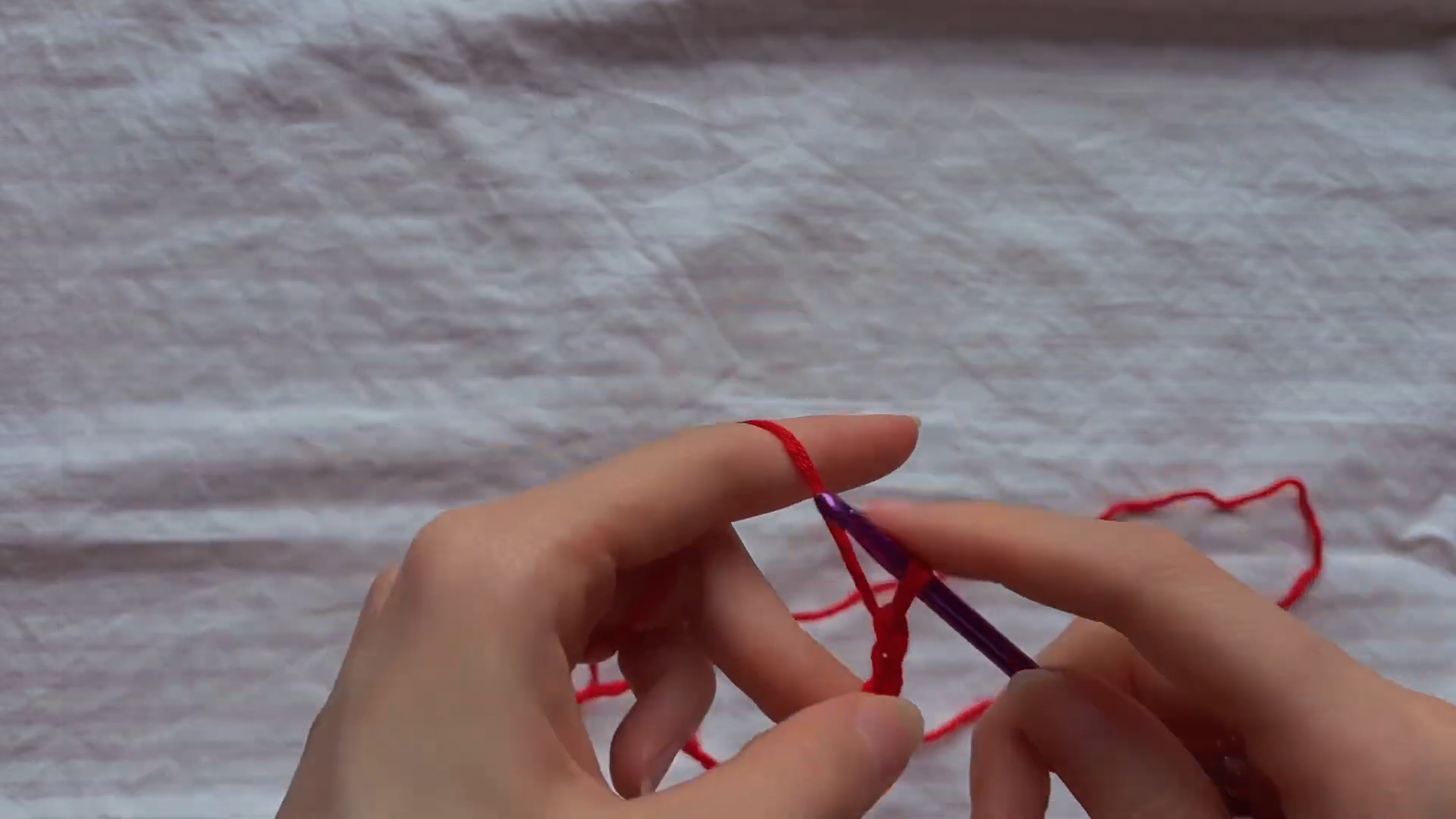 Starting a chain stitch with red yarn for a crochet top