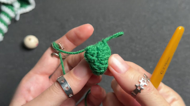 Twisting a green crochet piece into shape.