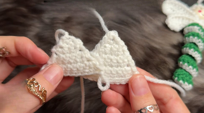 Two small white crochet triangle pieces held side by side.