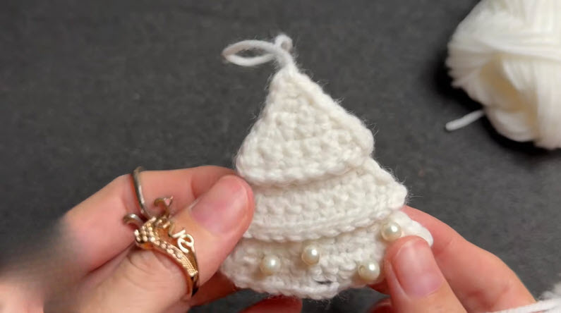 White crochet layered tree shape decorated with pearl beads.