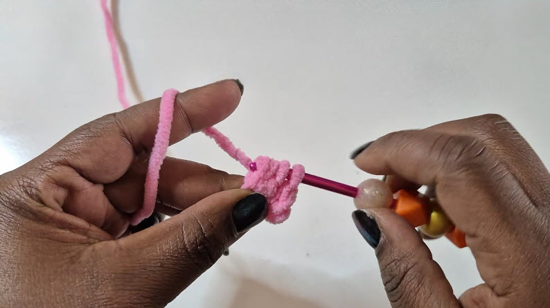 Working bobble stitches on pink crochet piece