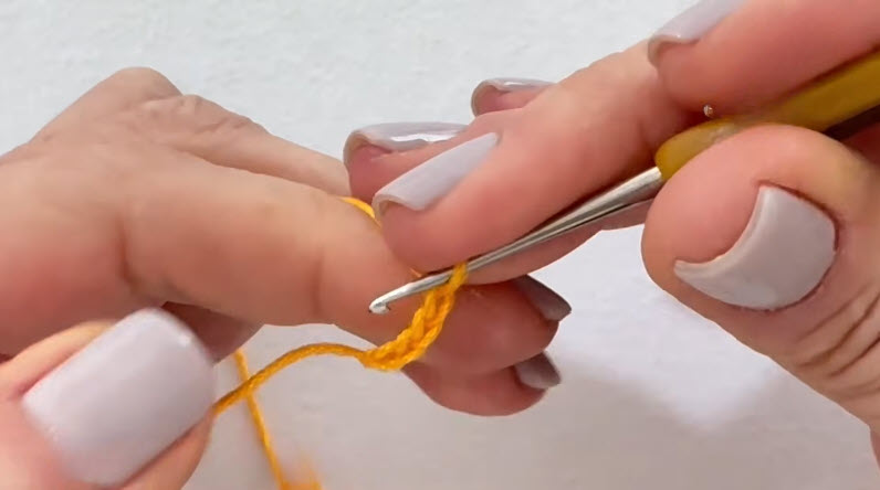 Working chain stitches with yellow crochet yarn