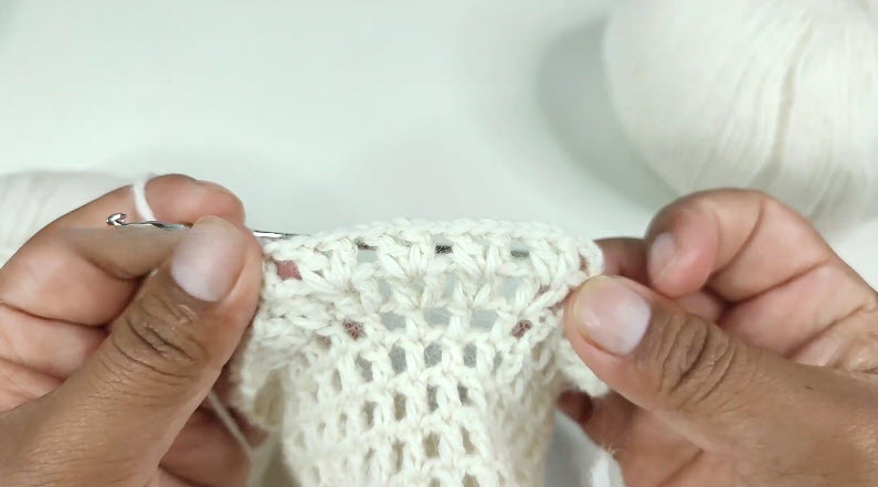 Working mesh stitch pattern in white crochet sweater