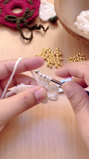 Working multiple loops on the hook to form a popcorn stitch.
