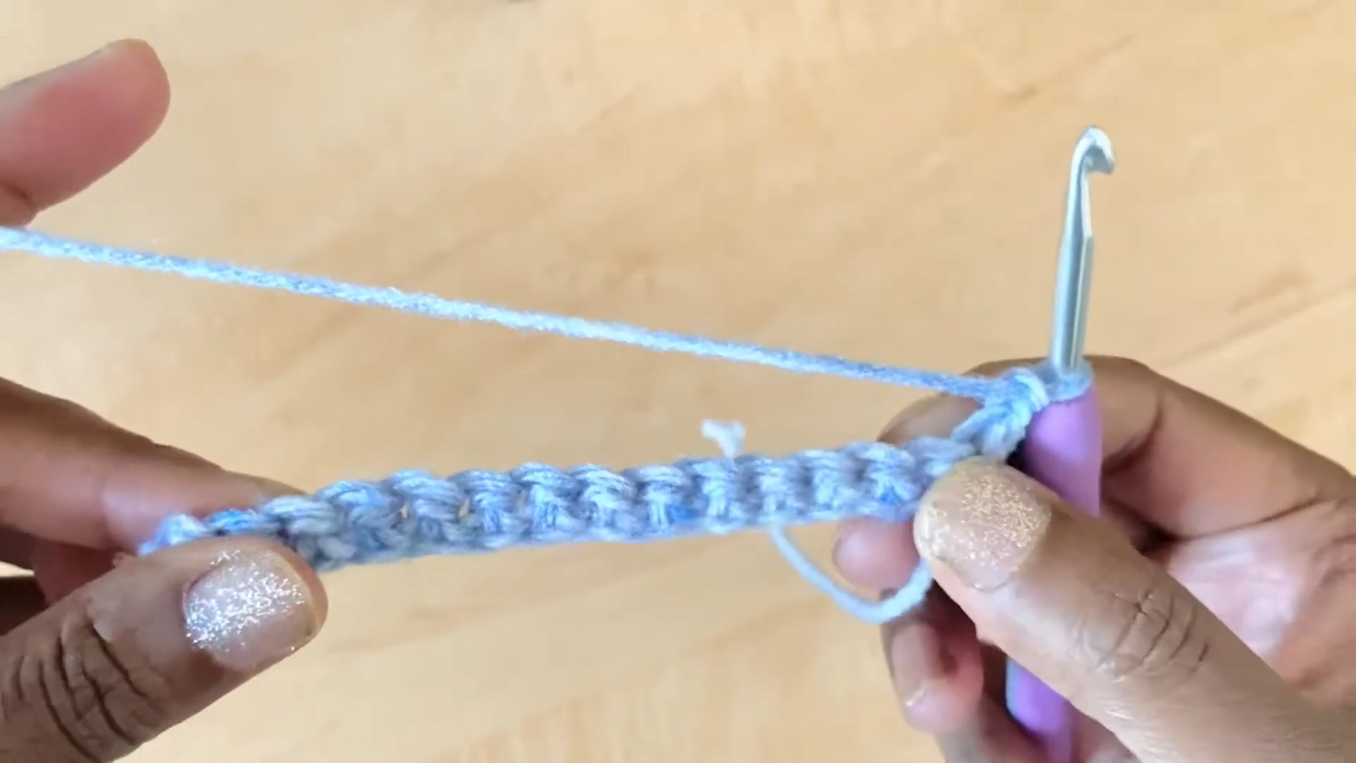 Working single crochet stitches in blue yarn