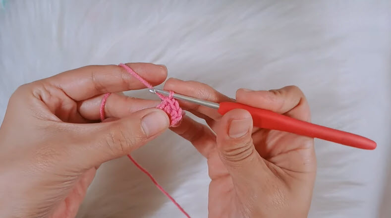 Working single crochet stitches in pink yarn