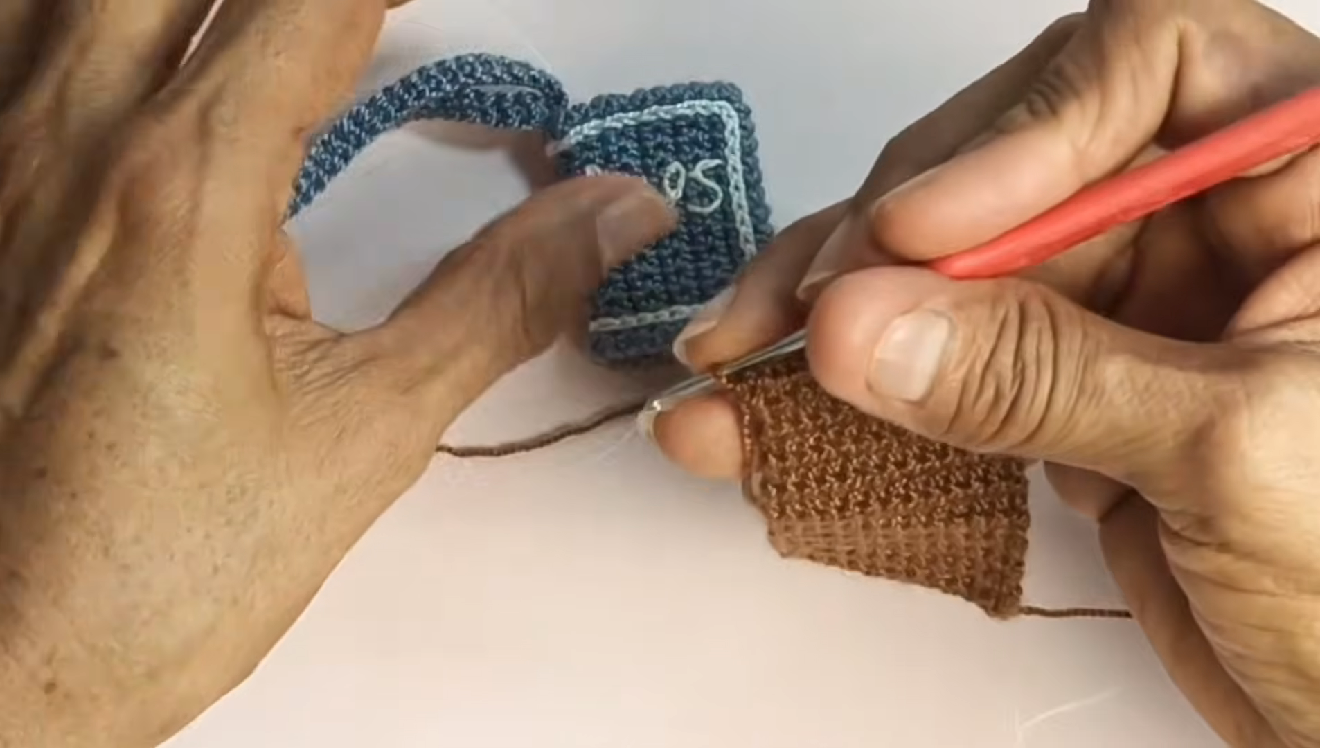 Crocheting the brown panel beside the blue piece.
