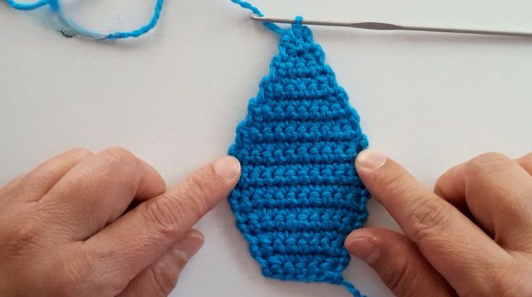 Finished blue teardrop shape of the crochet iron pattern at 53 stitches.