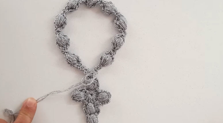 Finished gray crochet rosary bracelet with puff beads and a cross