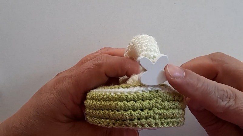 Green and white layers with a small white clip holding the handle.