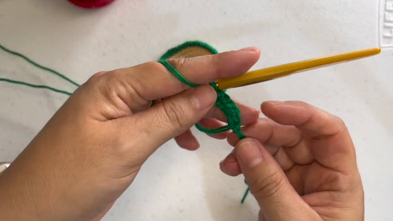 Holding green yarn to start the magic ring