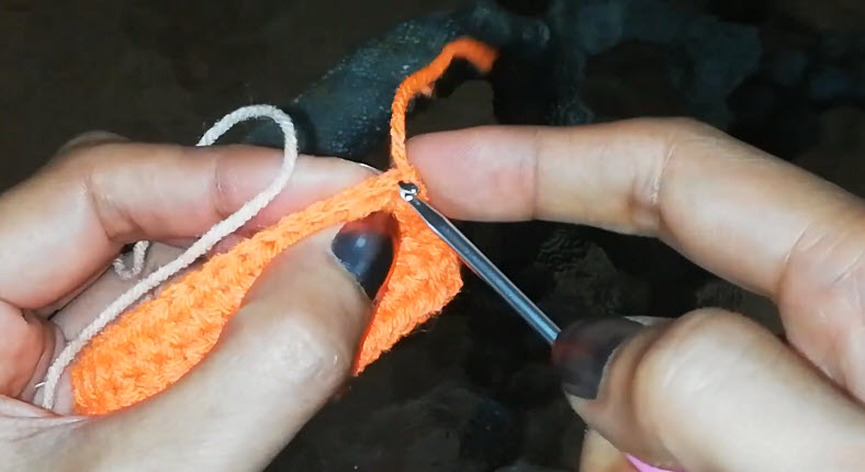 Joining cream yarn to the orange strip to begin a new color.