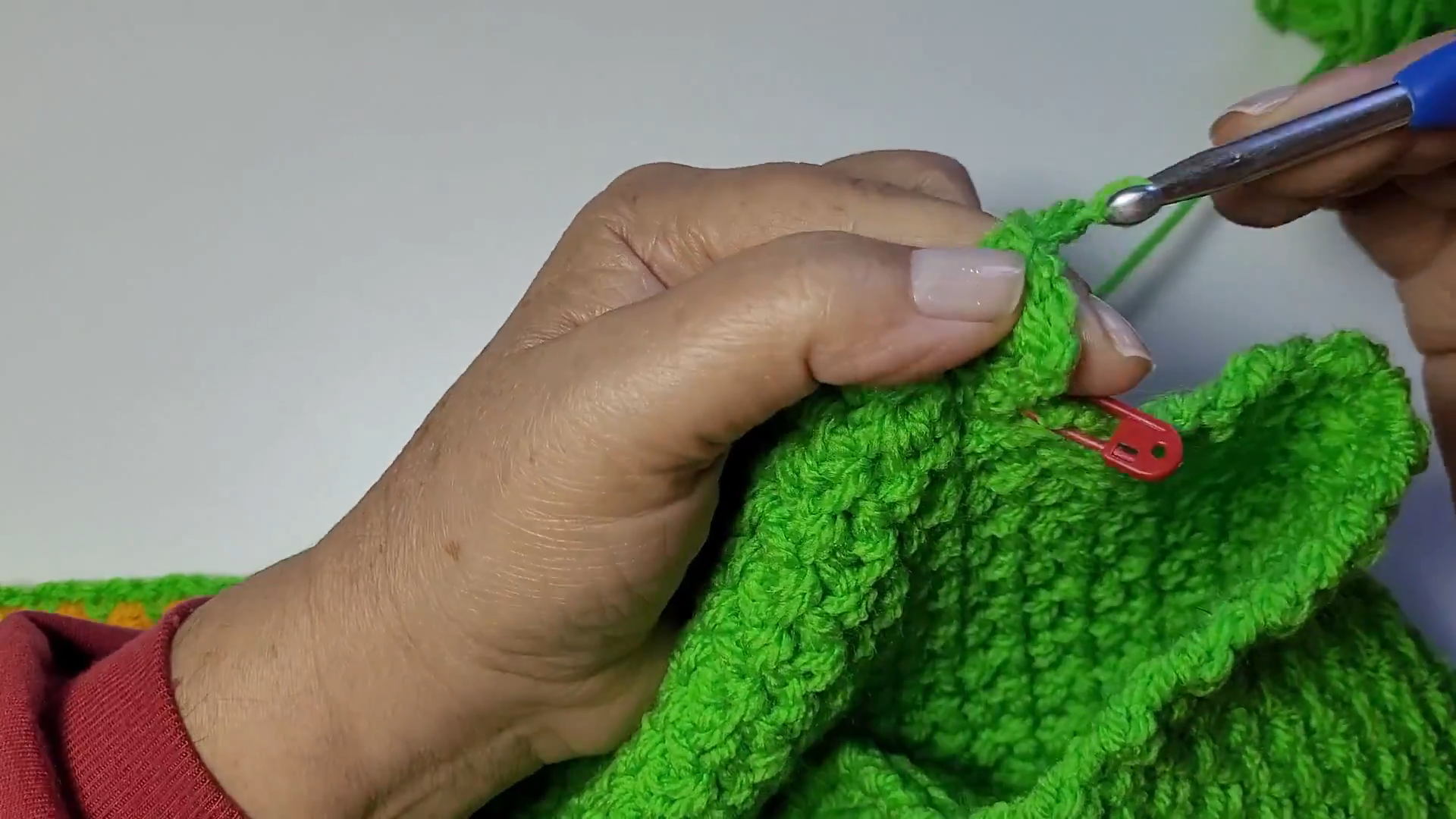 Joining a cardigan seam with the hook and a red stitch marker in place