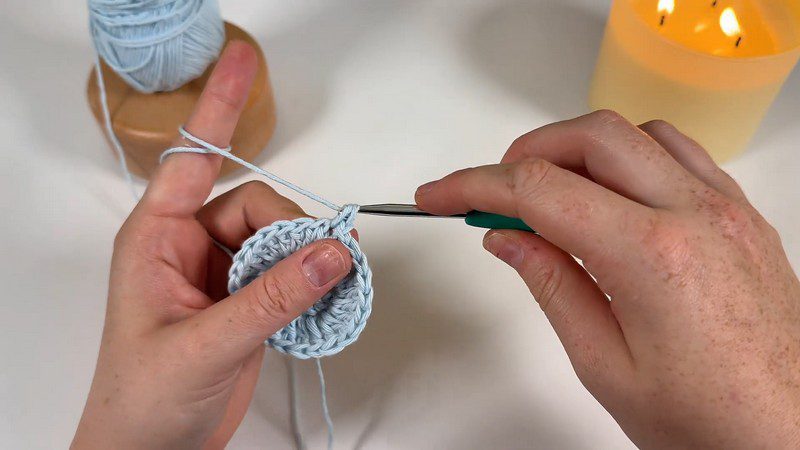 Light blue base circle for the daisy car coaster crochet with the hook ready