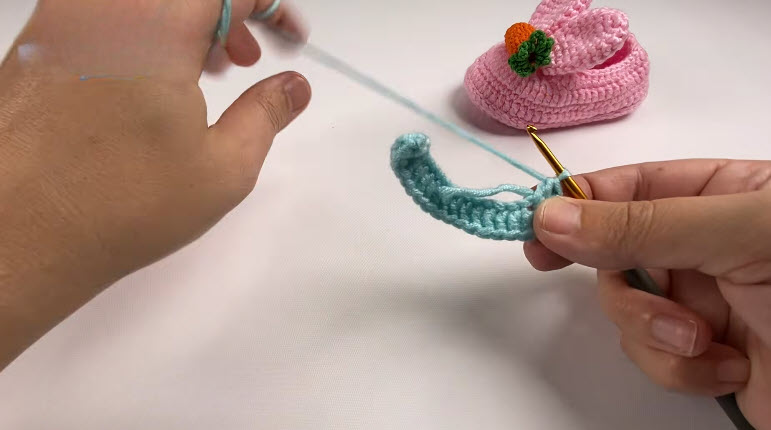 Light blue yarn foundation row with six double crochets in the last chain.
