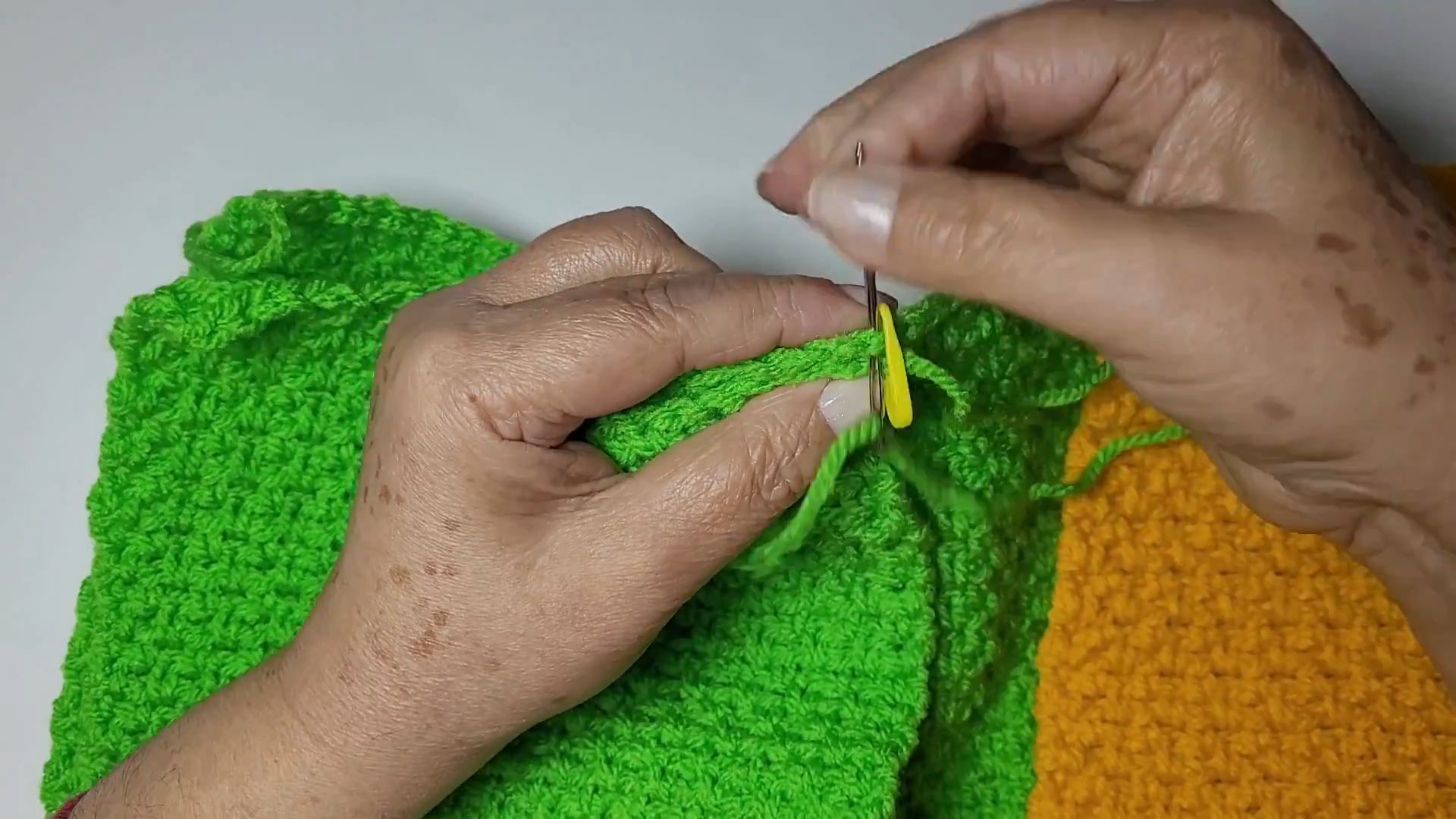 Pinning the green panel edges together with a stitch marker before seaming