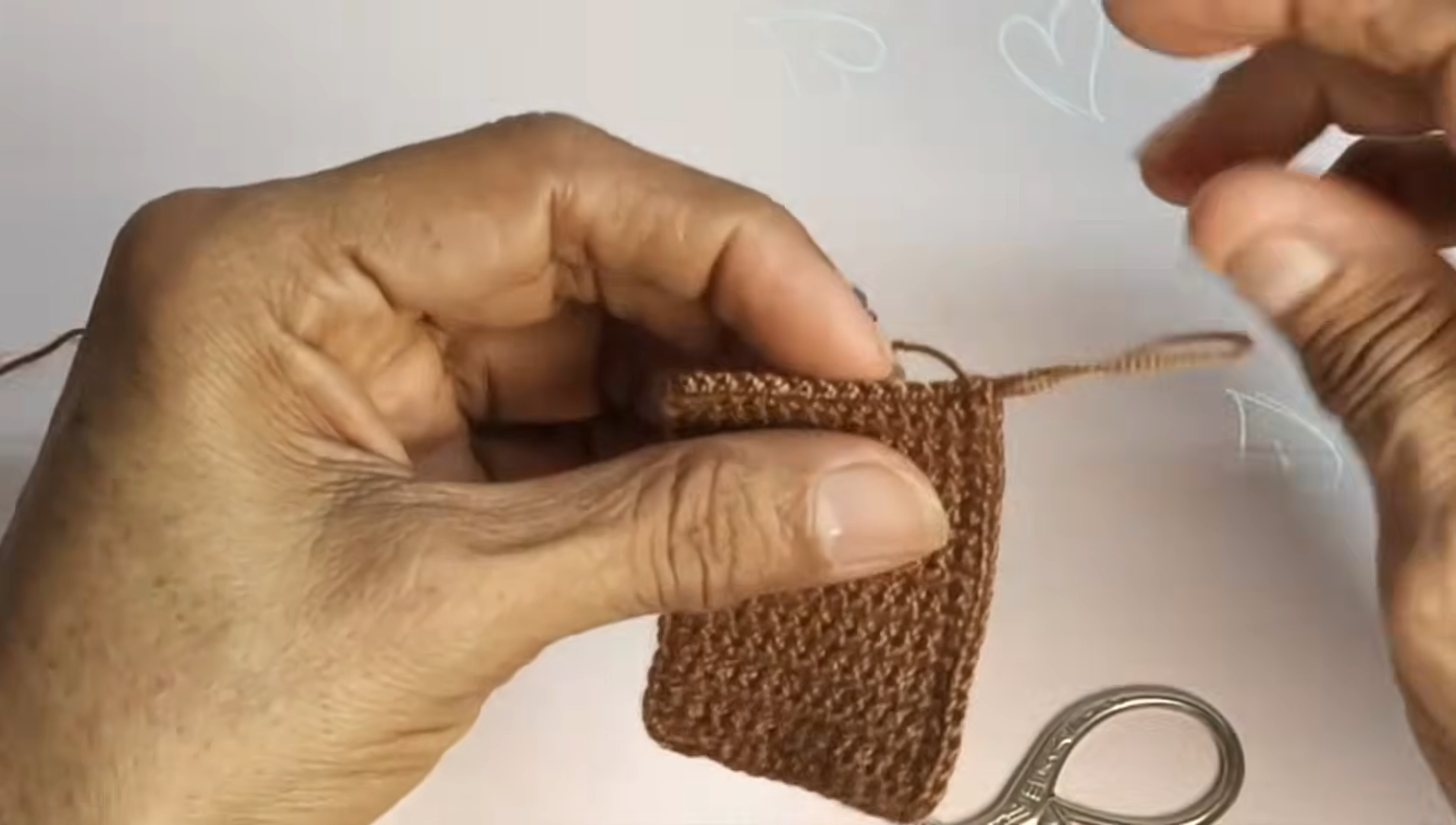 Placing a small white piece onto the brown panel.